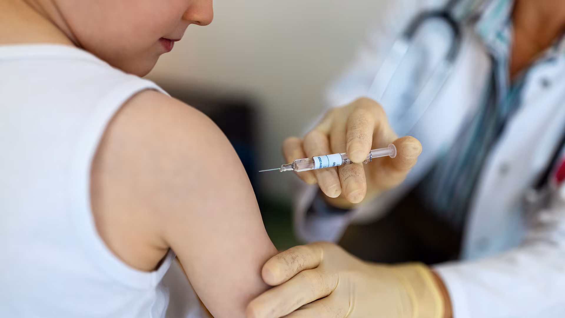 Personal de salud aplicando una vacuna en el brazo de un niño